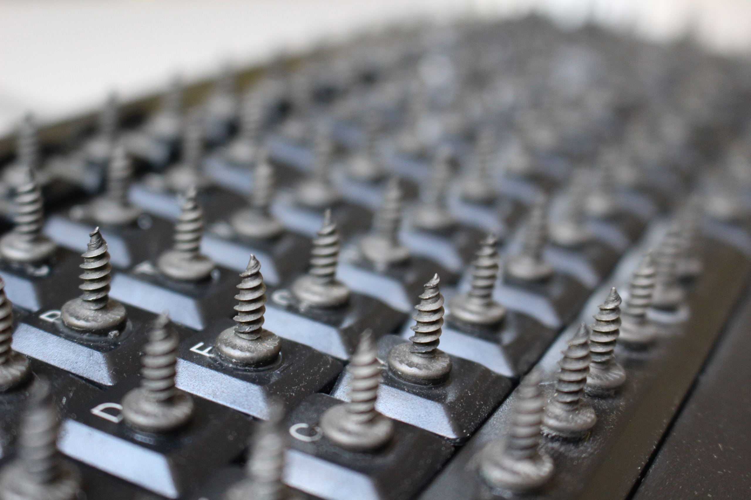 Close up of <i>Reticence</i>, version one. A keyboard with short screws glued to each key. Picture taken by Steven LeMieux