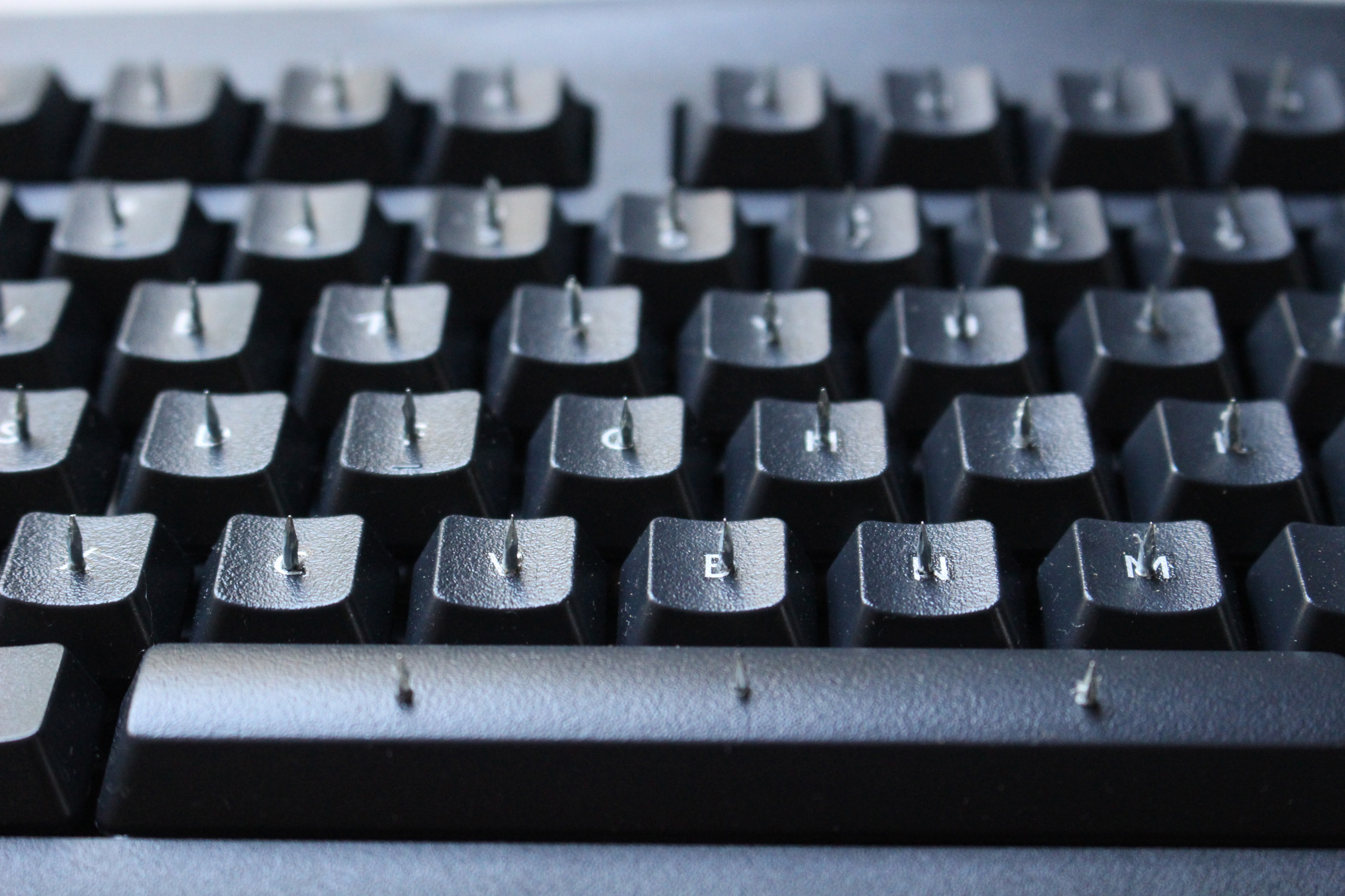 Close up of Reticence, version two. A keyboard with thin nails driven through each key. The sharp end emerges through the letter on each key. Picture taken by Steven LeMieux